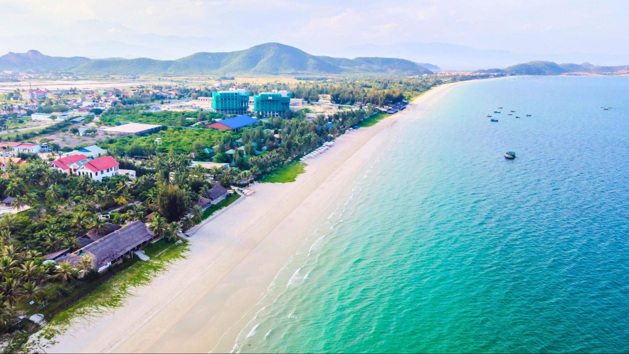 The long white sand beach embracing clear blue sea water of Doc Let Beach